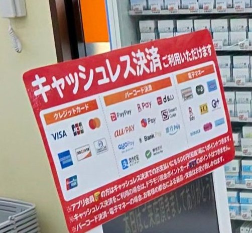 ドラッグストアモリ赤松店のレジの「キャッシュレス決済ご利用いただけます」の掲示。クレジットカード7ブランド、バーコード決済11種、電子マネーのロゴ