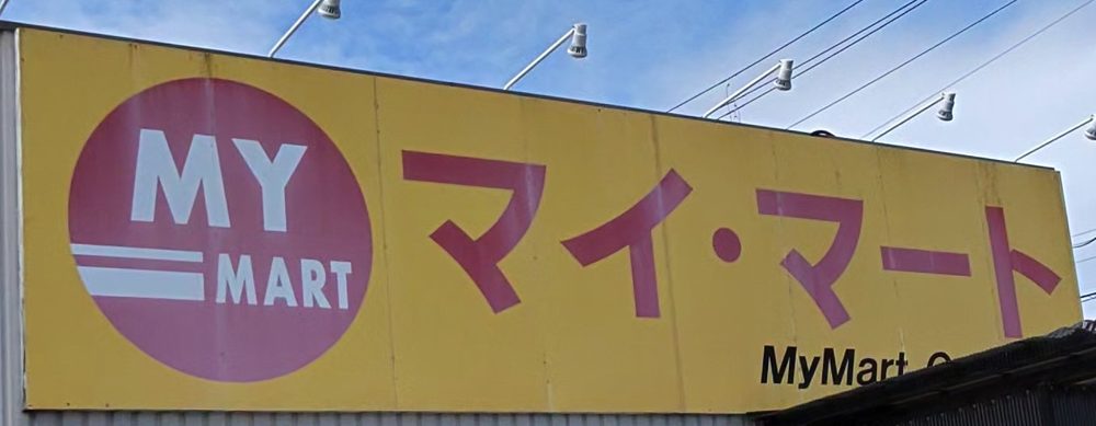 マイマート三原店の看板。黄色の地に赤い「MY MART」のマークと「マイ・マート」の文字