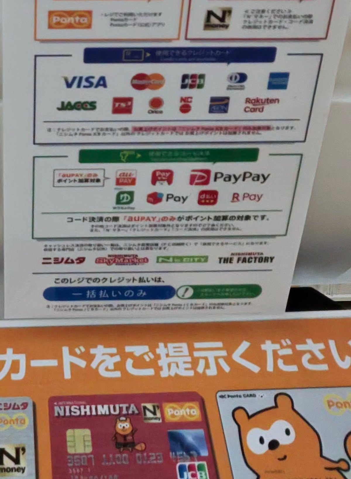 ニシムタ指宿店のレジに貼られた「ニシムタでご利用いただけます」の掲示。Ponta・N'マネー・クレジットカード5ブランド・コード決済7種
