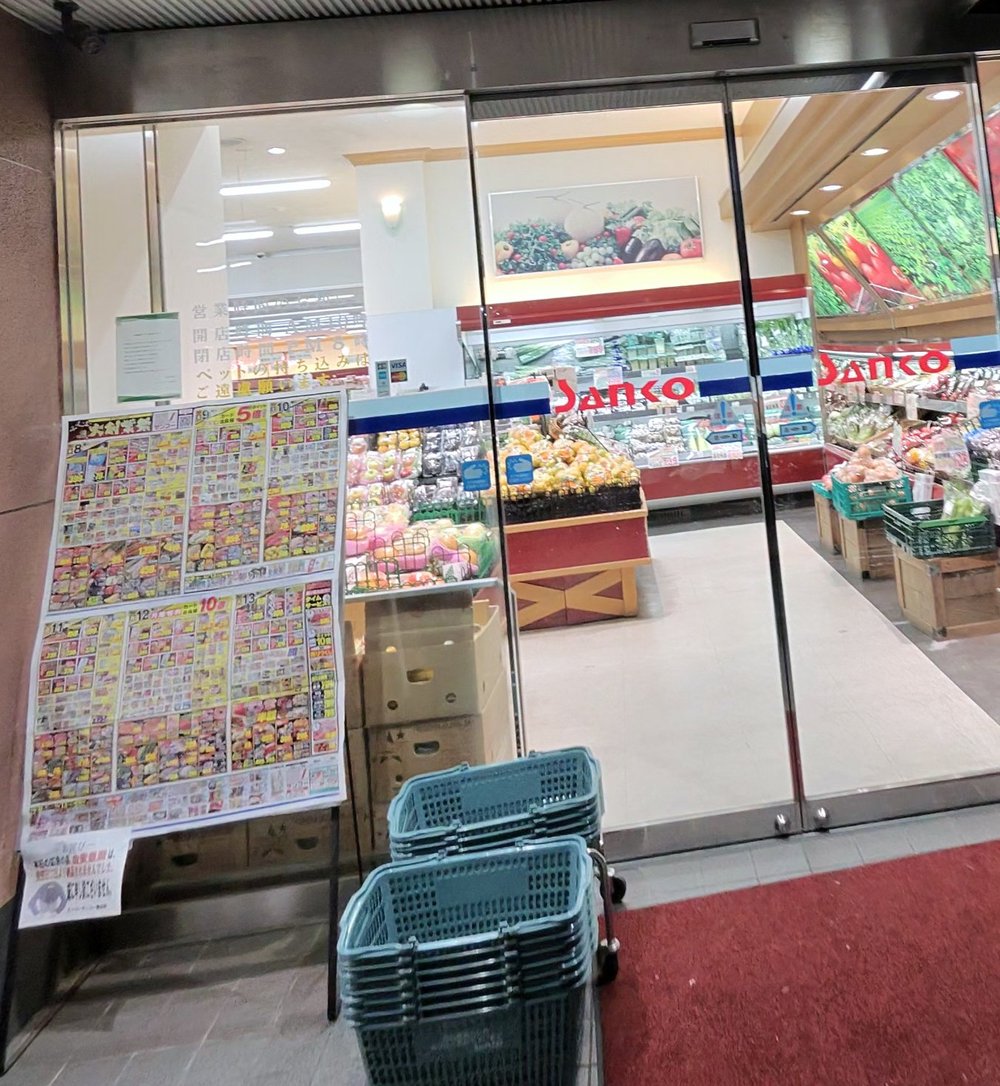 スーパーサンコー横沼店の入口。赤いSankoのロゴと、店先のチラシ